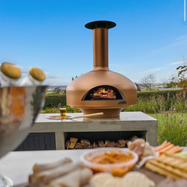 Polito_Giotto_pizza_oven_Copper_outdoors_with_flame_food_blurred_in_front